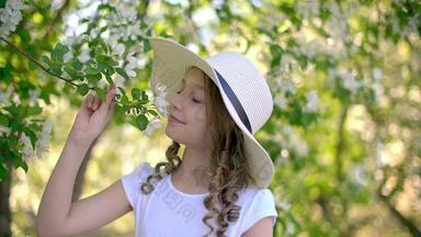 可爱的女孩嗅探开花树分支水果花园春天一天微笑女孩少年白色他享受味道盛开的水果树夏天果园